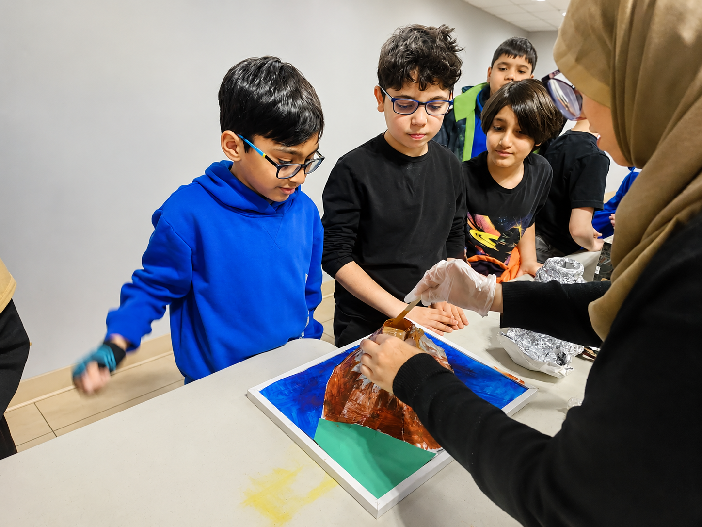Students working on a classroom art and science project with their teacher