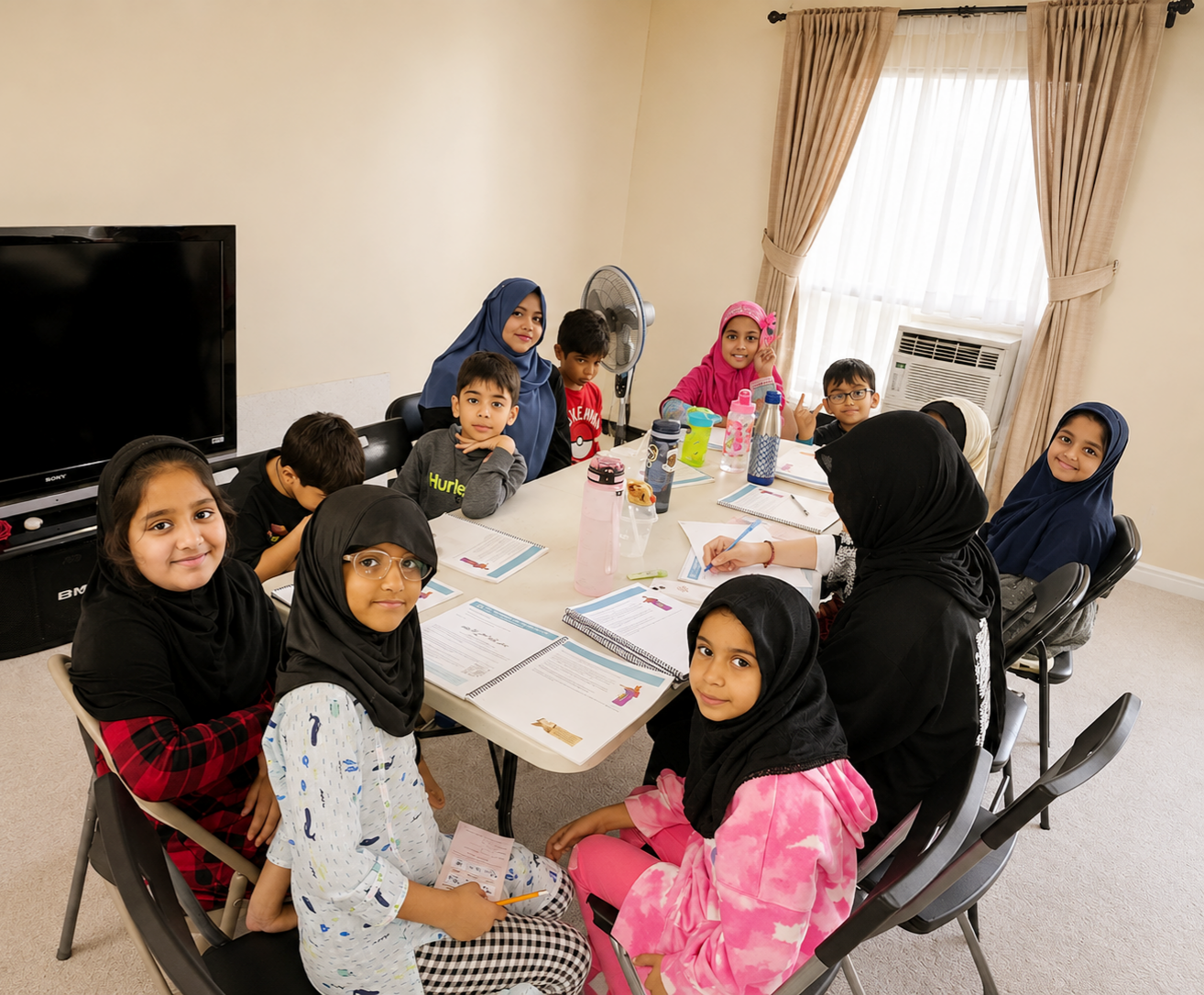 Zainabia Academy students at their workbooks in a classroom