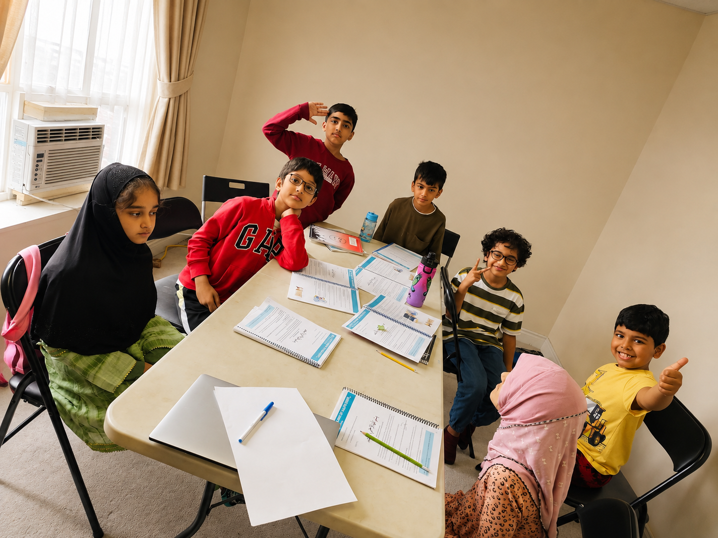 A Deeniyat class working through their workbooks around a table