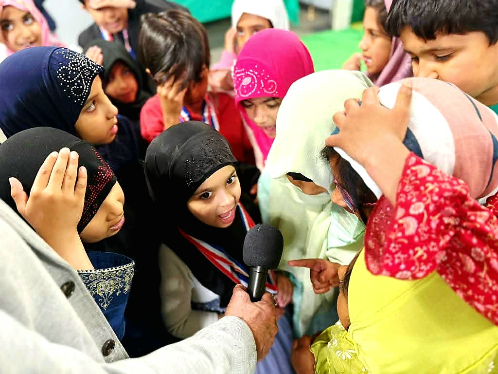 Students answering questions into a microphone during an academy program