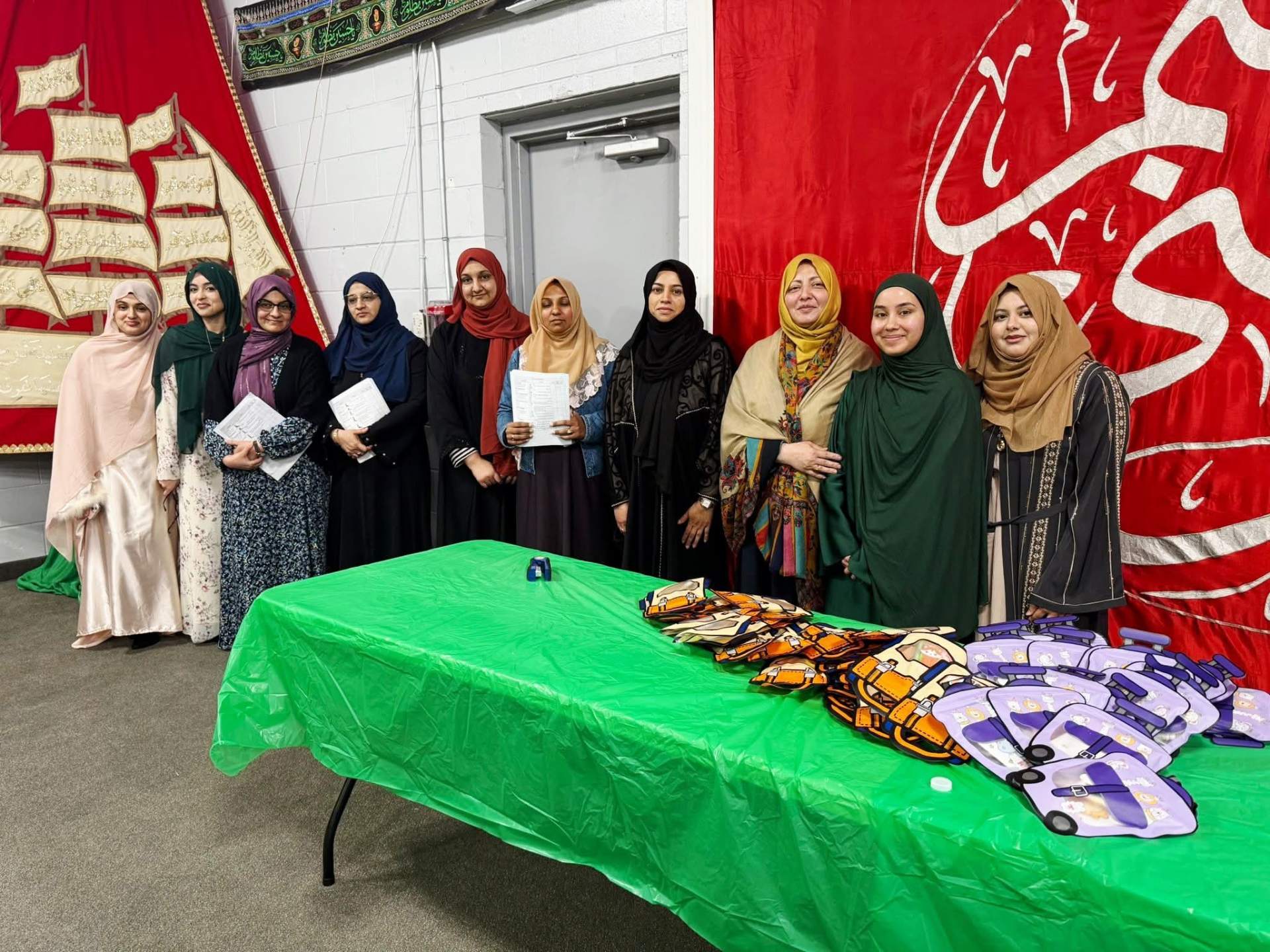 Zainabia Academy teachers together at a school supplies distribution table